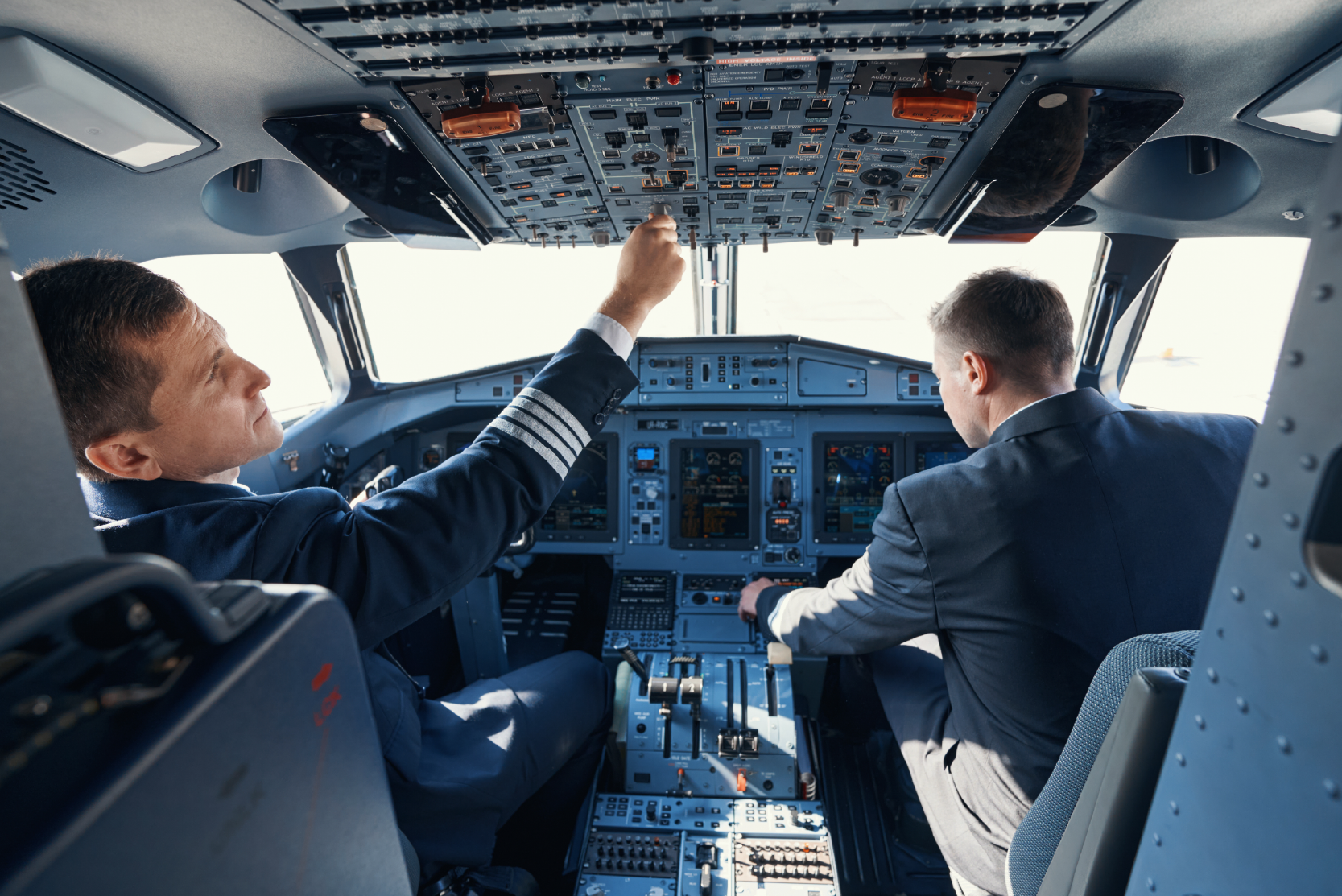 two-male-pilots-in-cockpit-checking-systems